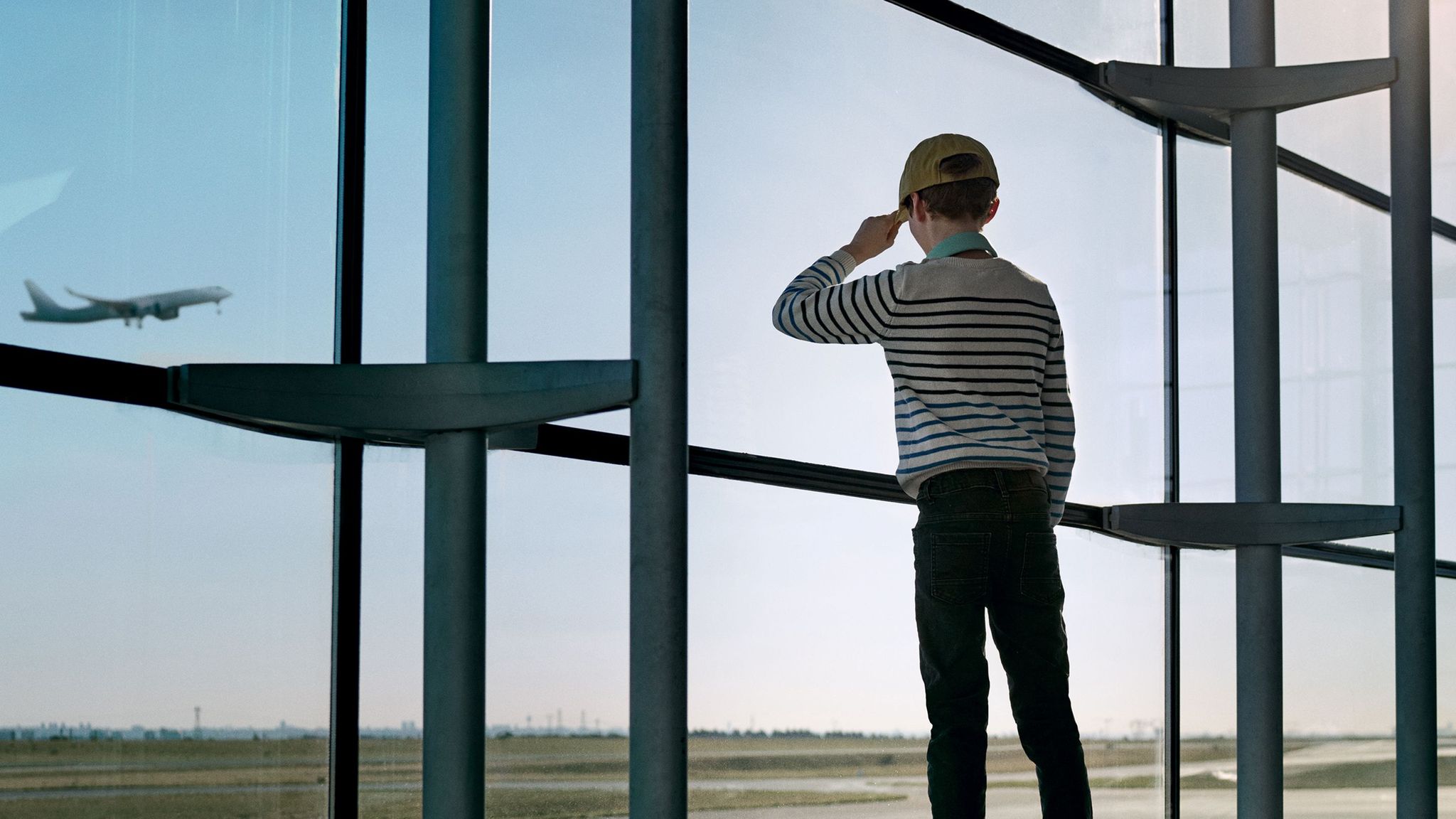 enfant mineur regarde avion voler à l'aéroport